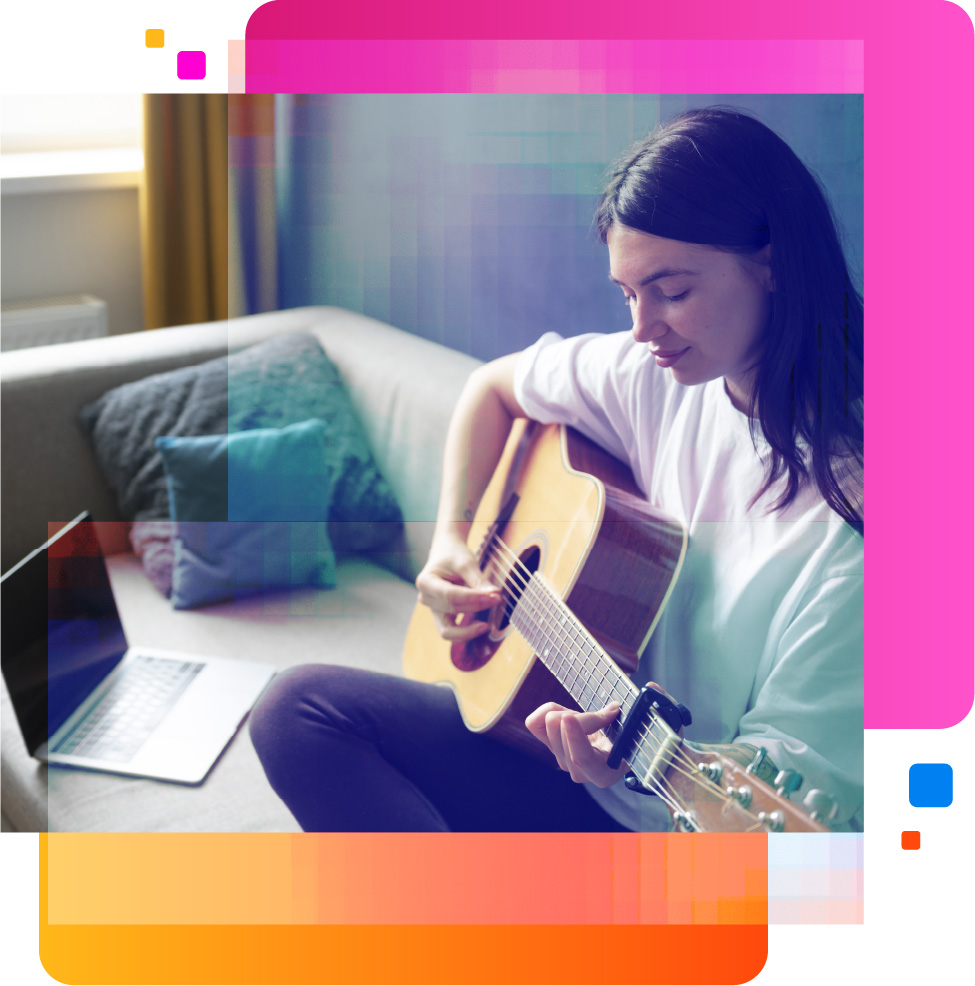 Teen girl playing guitar in front of laptop